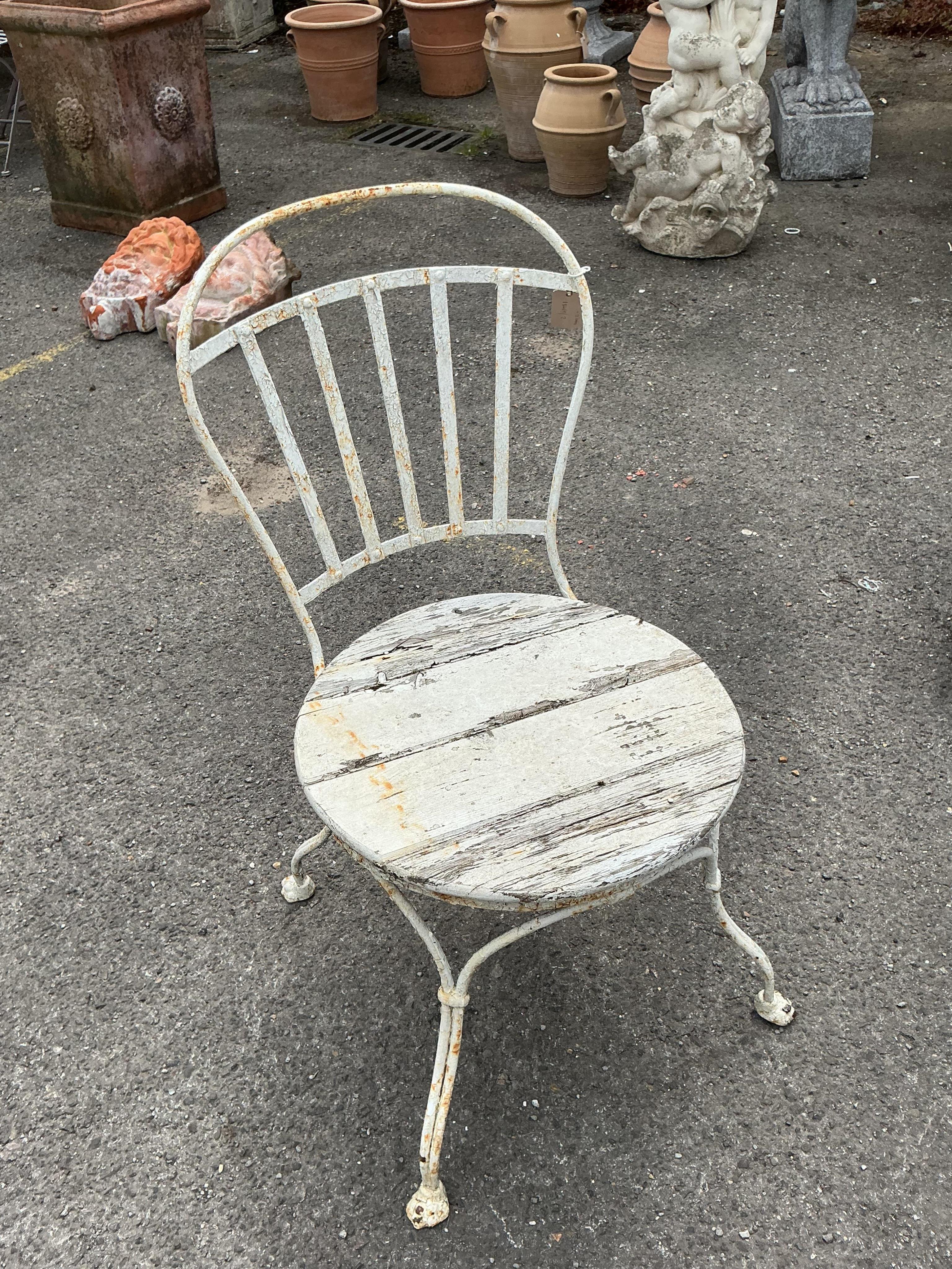 A Victorian Coalbrookdale style later painted circular cast iron garden table, diameter 61cm, height 70cm together with two later chairs